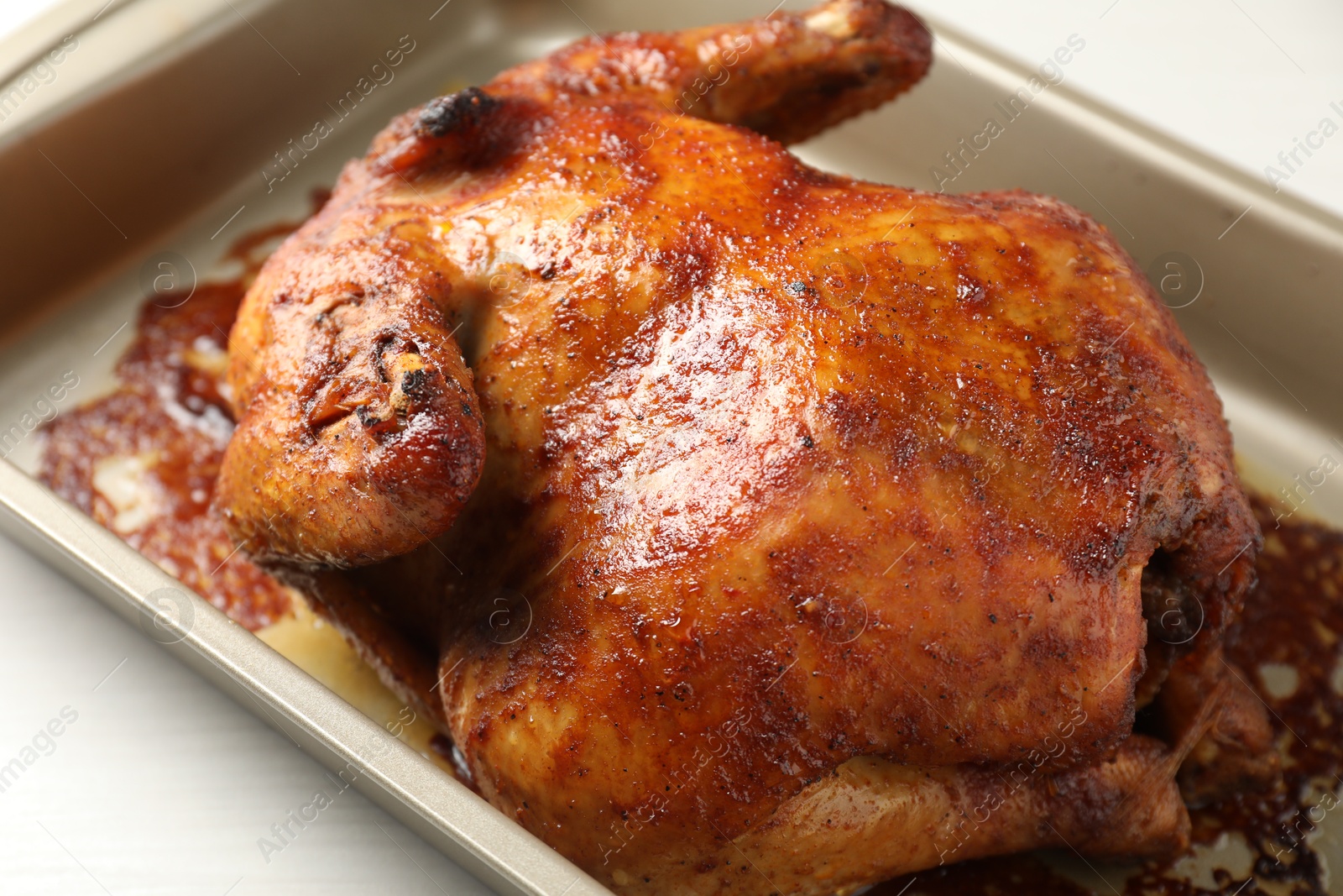 Photo of Delicious baked turkey in baking dish on light table, closeup