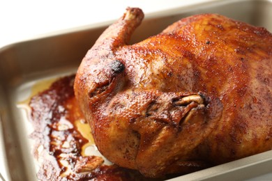 Photo of Delicious baked turkey in baking dish on light table, closeup