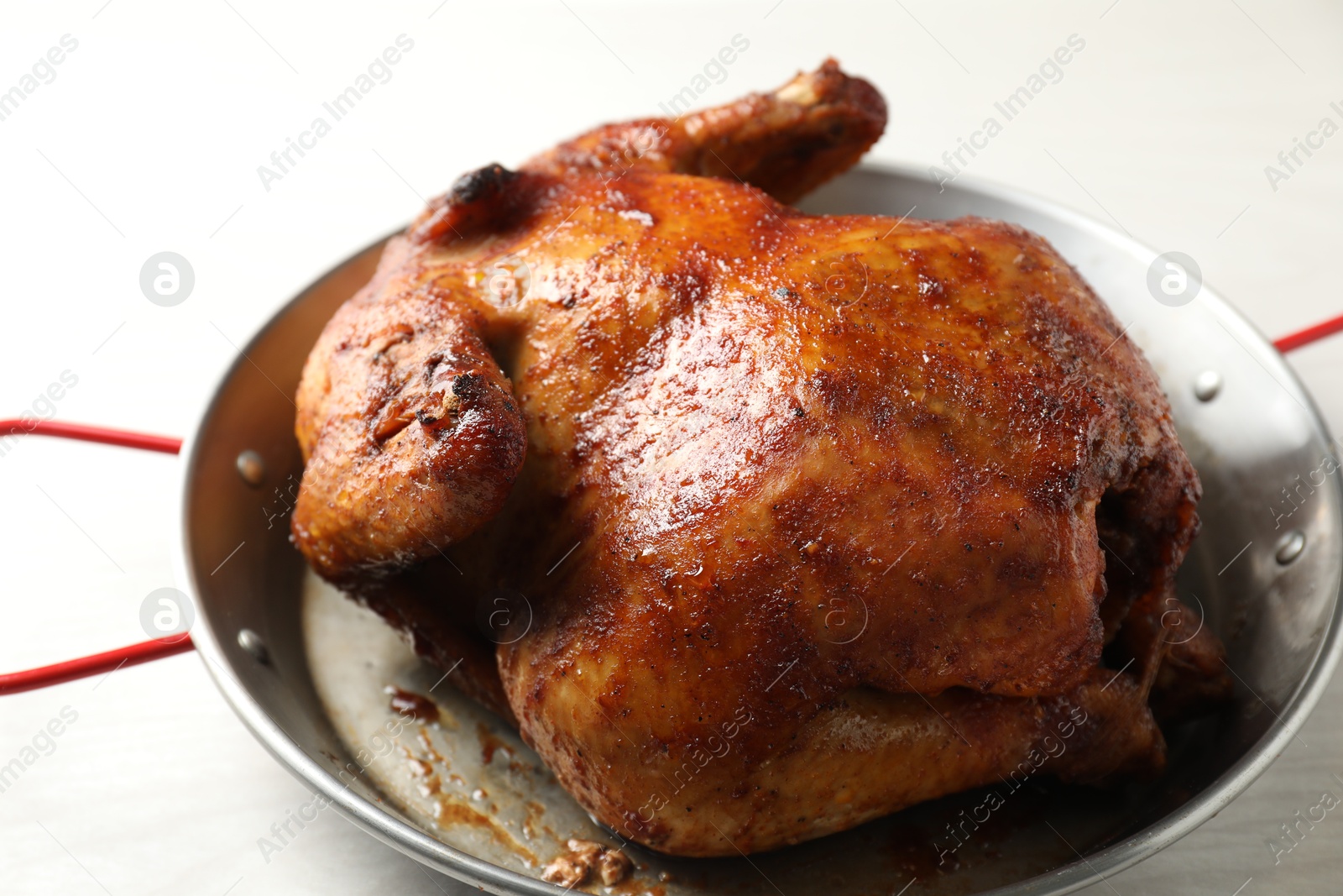 Photo of Delicious baked turkey in baking dish on light table, closeup