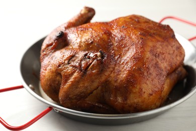 Photo of Delicious baked turkey in baking dish on light table, closeup