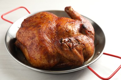 Photo of Delicious baked turkey in baking dish on light table, closeup