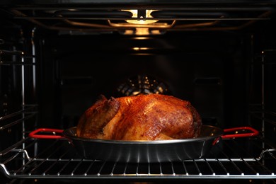 Photo of Delicious baked turkey in baking dish in oven