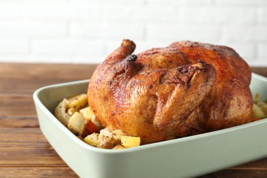 Photo of Delicious baked turkey and vegetables in baking dish on wooden table, closeup