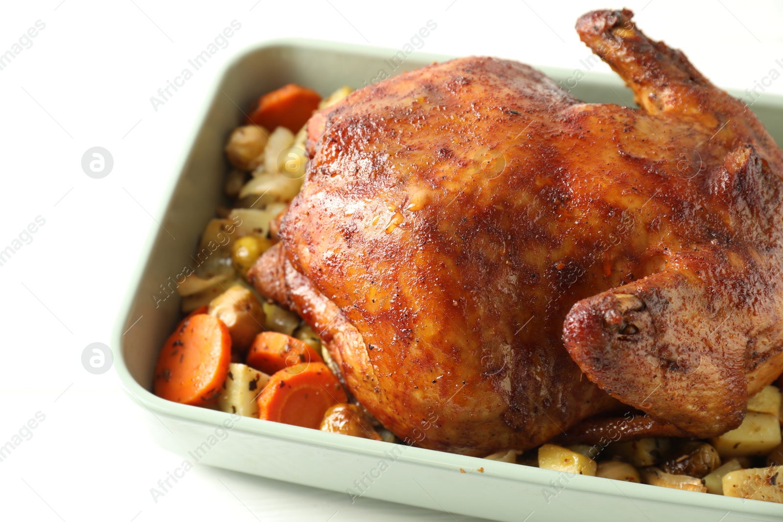 Photo of Delicious baked turkey and vegetables in baking dish on white table, closeup