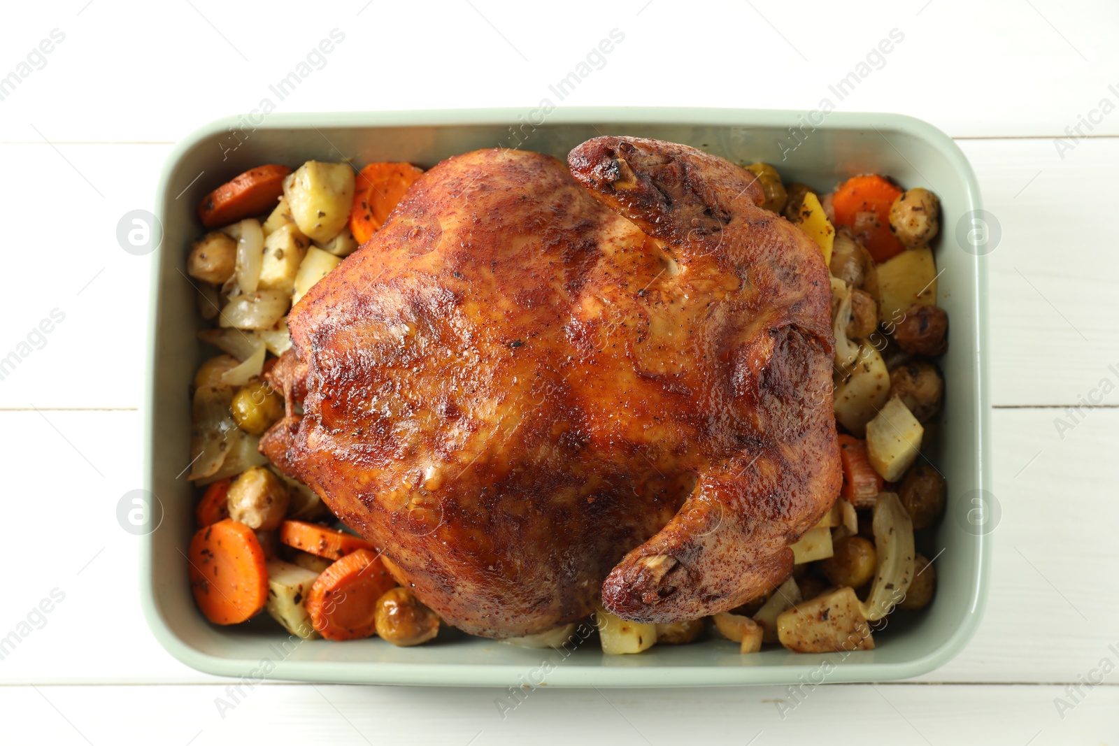 Photo of Delicious baked turkey and vegetables in baking dish on white wooden table, top view