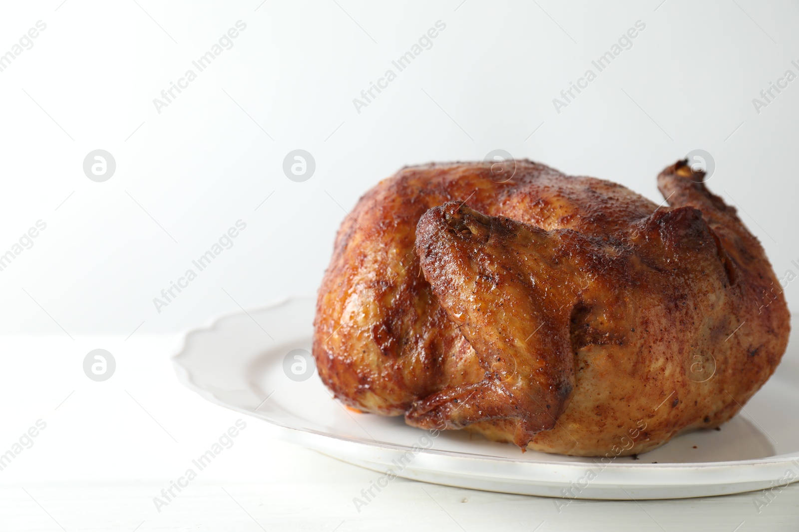 Photo of Delicious baked turkey on white table, space for text