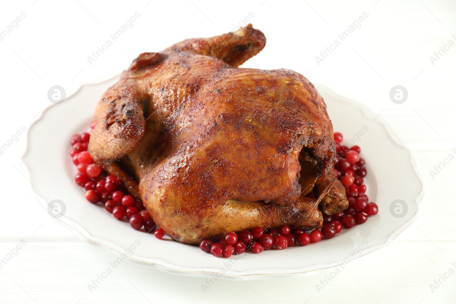 Photo of Delicious baked turkey and cranberries on white table, closeup