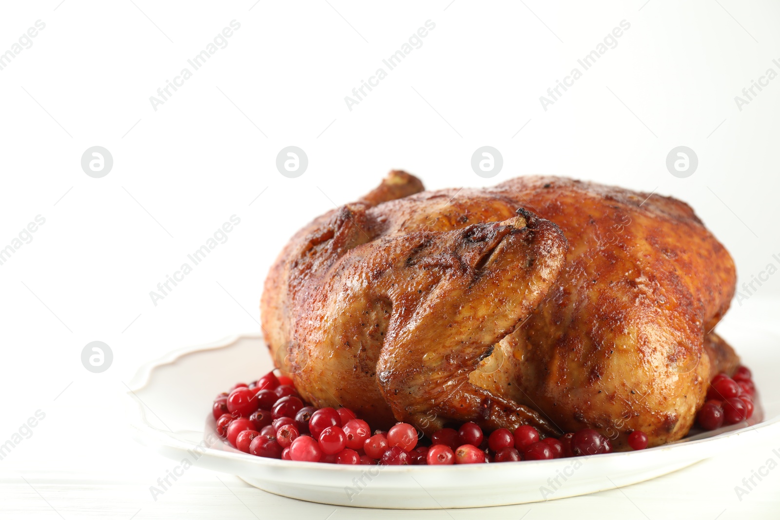 Photo of Delicious baked turkey and cranberries on white table, space for text