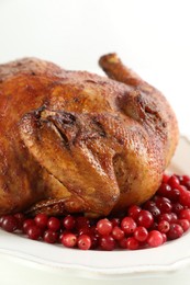 Photo of Delicious baked turkey and cranberries on white table, closeup