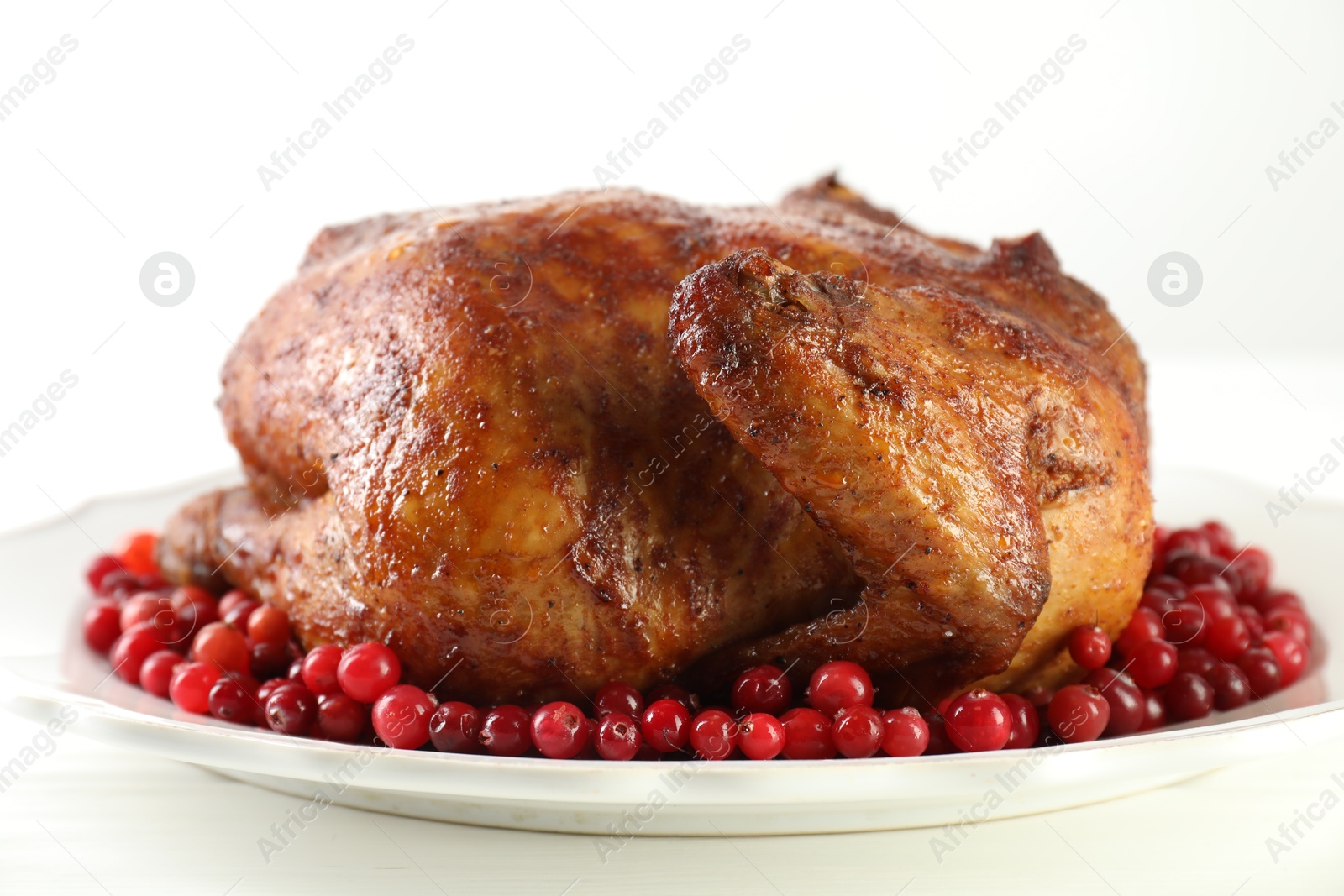 Photo of Delicious baked turkey and cranberries on white table, closeup