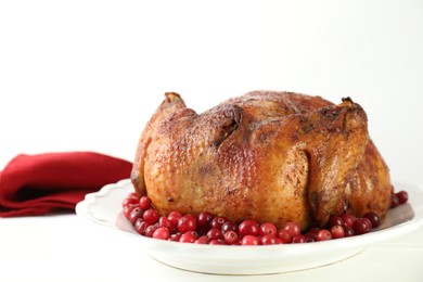 Photo of Delicious baked turkey and cranberries on white table, closeup. Space for text