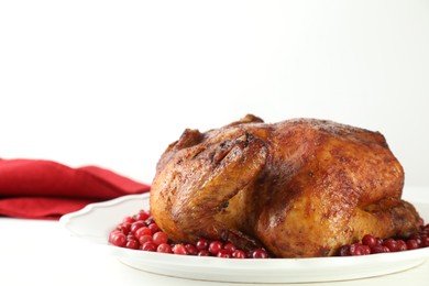 Photo of Delicious baked turkey and cranberries on white table, closeup. Space for text