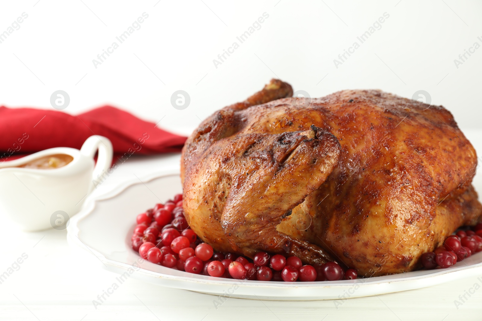 Photo of Delicious baked turkey and cranberries on white wooden table, closeup