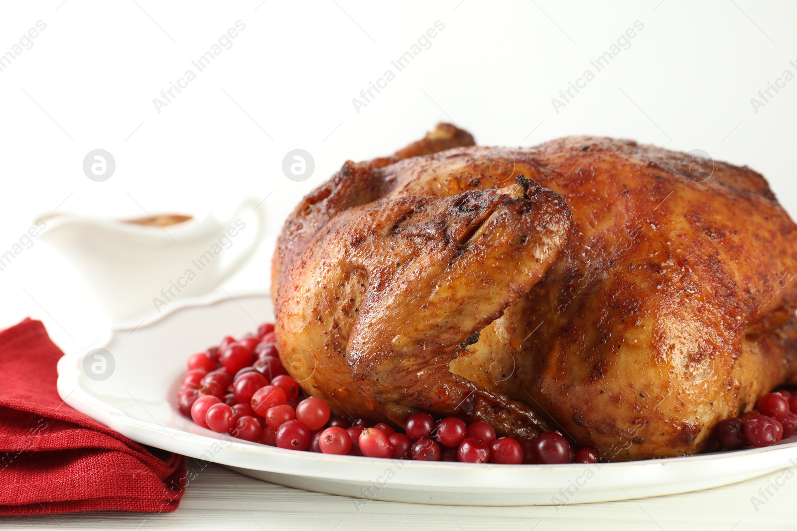 Photo of Delicious baked turkey and cranberries on white wooden table, closeup