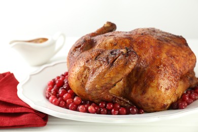 Photo of Delicious baked turkey and cranberries on white wooden table, closeup