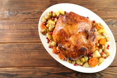 Photo of Delicious baked turkey, vegetables and cranberries on wooden table, top view. Space for text