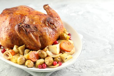 Photo of Delicious baked turkey, vegetables and cranberries on gray textured table, closeup. Space for text