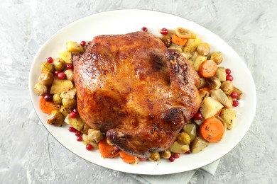 Photo of Delicious baked turkey, vegetables and cranberries on gray textured table, top view