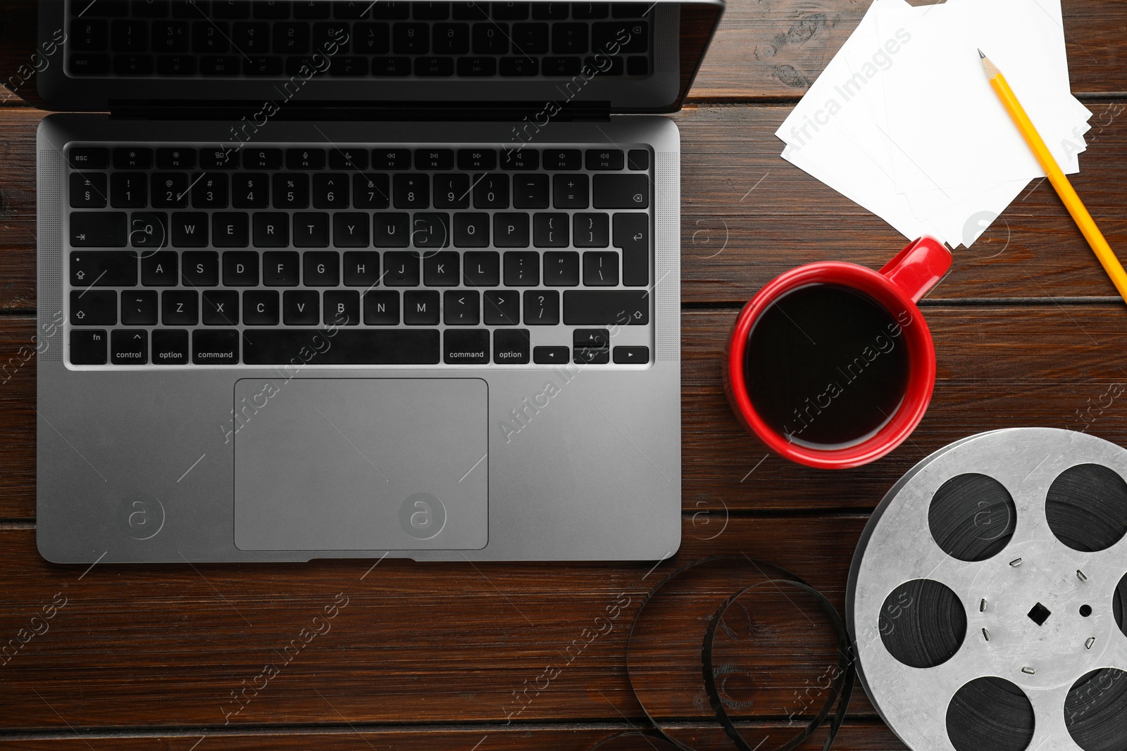 Photo of Flat lay composition with film reel and laptop on wooden table