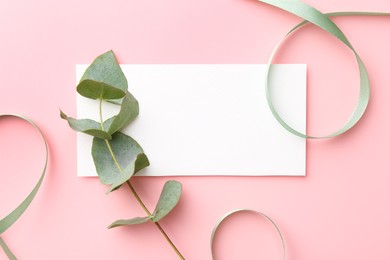 Blank card, ribbons and eucalyptus branch on pink background, flat lay