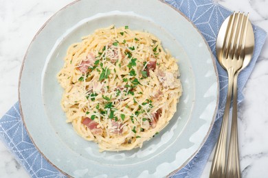 Photo of Delicious pasta Carbonara with bacon served on white marble table, flat lay