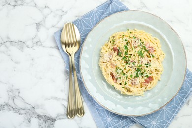 Photo of Delicious pasta Carbonara with bacon served on white marble table, flat lay