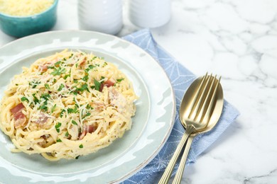 Photo of Delicious pasta Carbonara with bacon served on white marble table, closeup