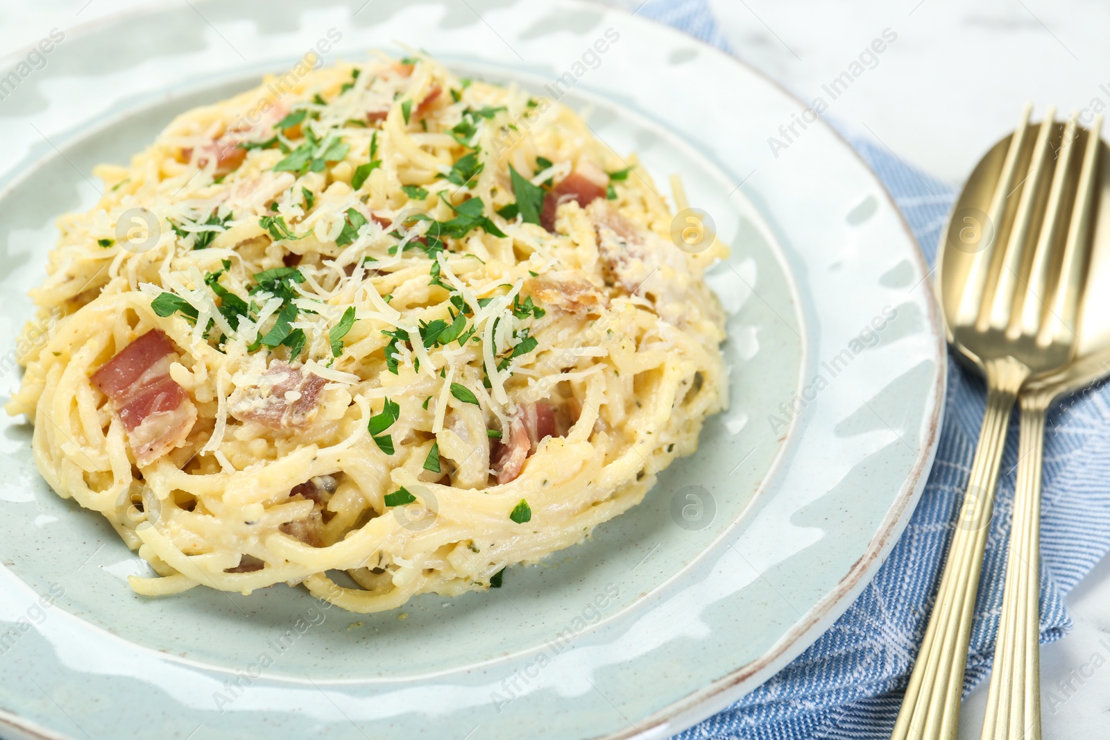 Photo of Delicious pasta Carbonara with bacon served on table, closeup