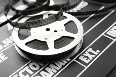 Photo of Movie clapper and film reel on table, closeup