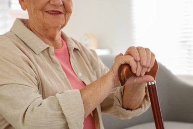 Photo of Senior woman with walking cane indoors, closeup