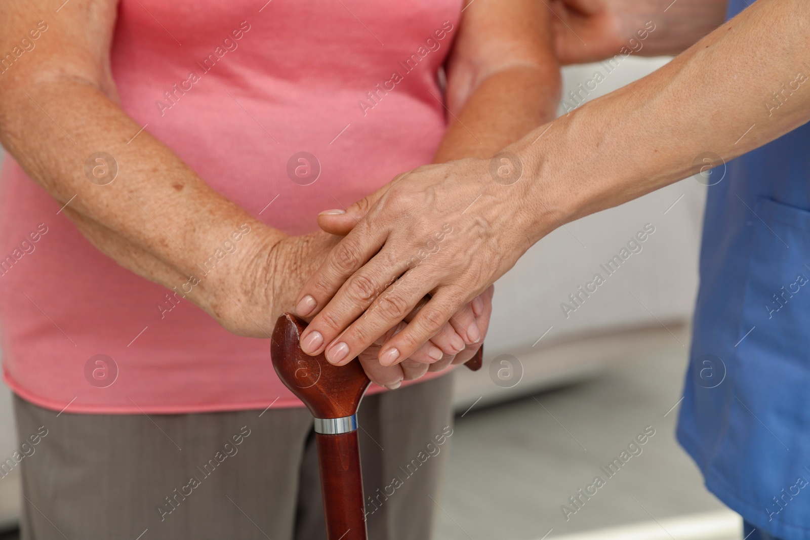 Photo of Healthcare worker supporting senior patient indoors, closeup