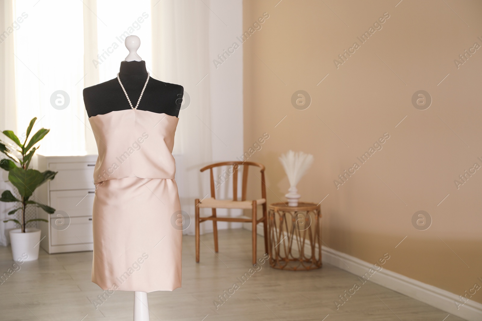 Photo of Female mannequin with unfinished dress in workshop. Space for text