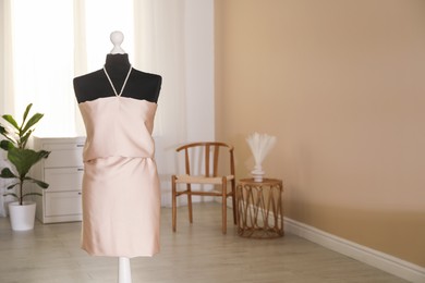 Photo of Female mannequin with unfinished dress in workshop. Space for text