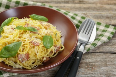 Photo of Delicious pasta Carbonara served on wooden table, closeup