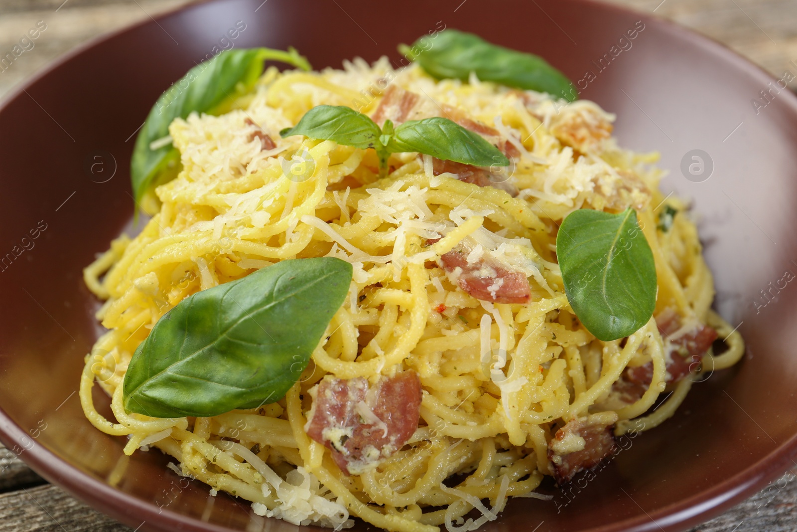 Photo of Delicious pasta Carbonara in bowl on table, closeup