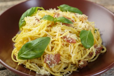 Photo of Delicious pasta Carbonara in bowl on table, closeup