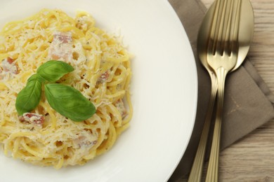 Photo of Delicious pasta Carbonara served on wooden table, flat lay