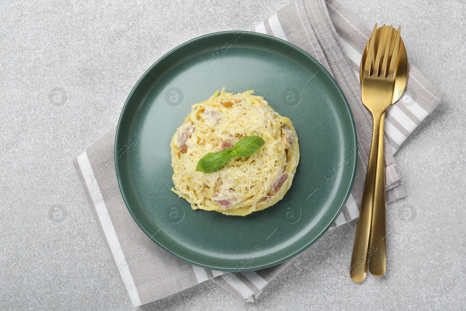 Photo of Delicious pasta Carbonara served on gray table, flat lay