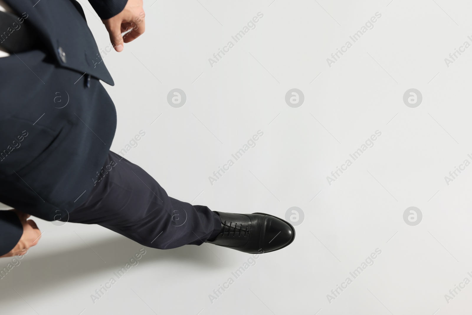 Photo of Businessman walking on light grey background, above view. Space for text