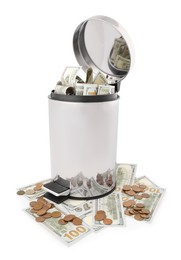 Photo of Dollar banknotes in trash bin and coins on white background