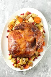 Photo of Delicious baked turkey, vegetables and cranberries on gray textured table, top view