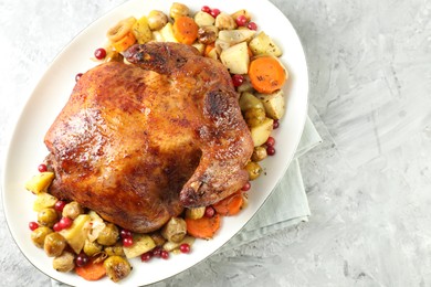 Photo of Delicious baked turkey, vegetables and cranberries on gray textured table, top view. Space for text