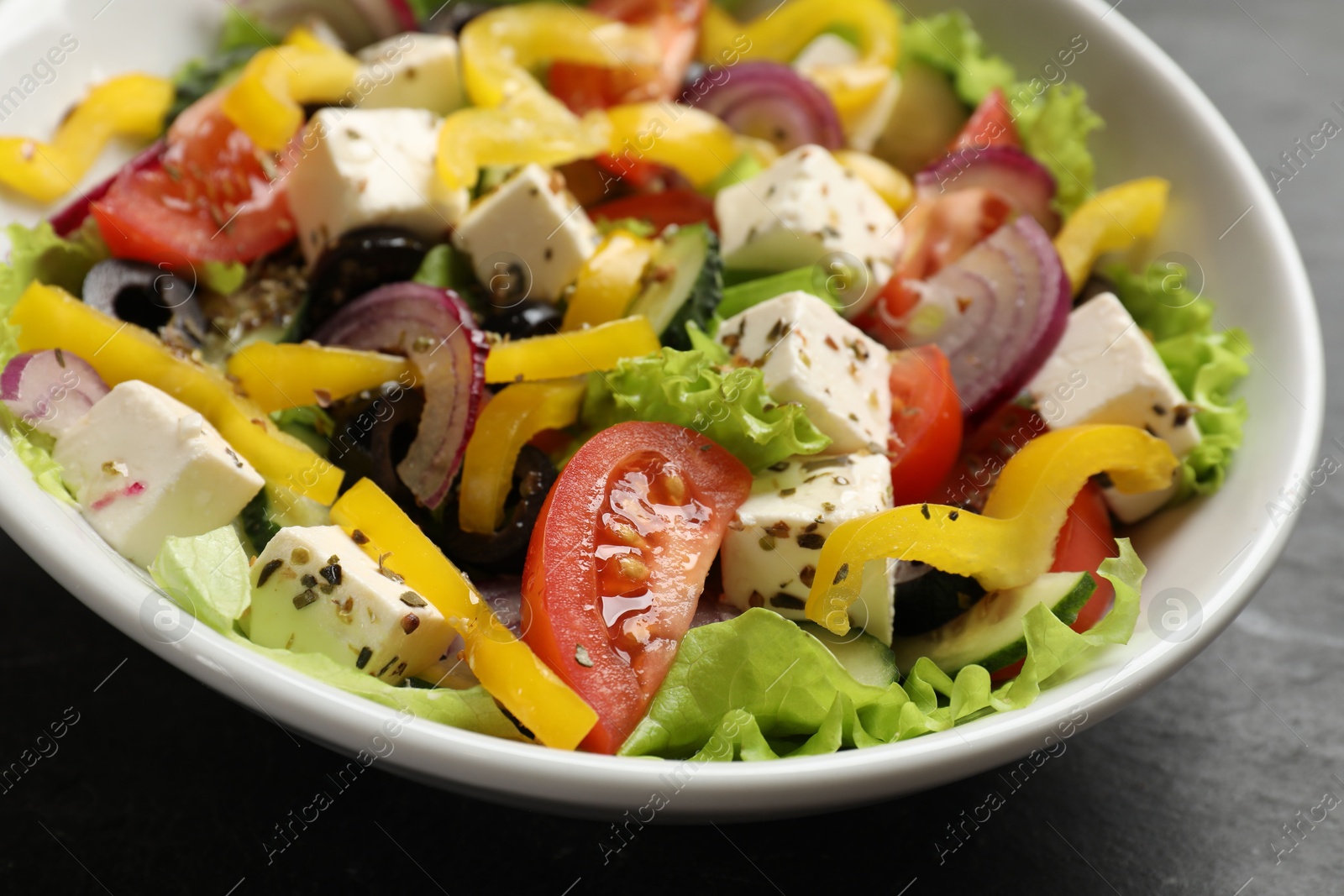 Photo of Delicious fresh Greek salad in bowl on table, closeup