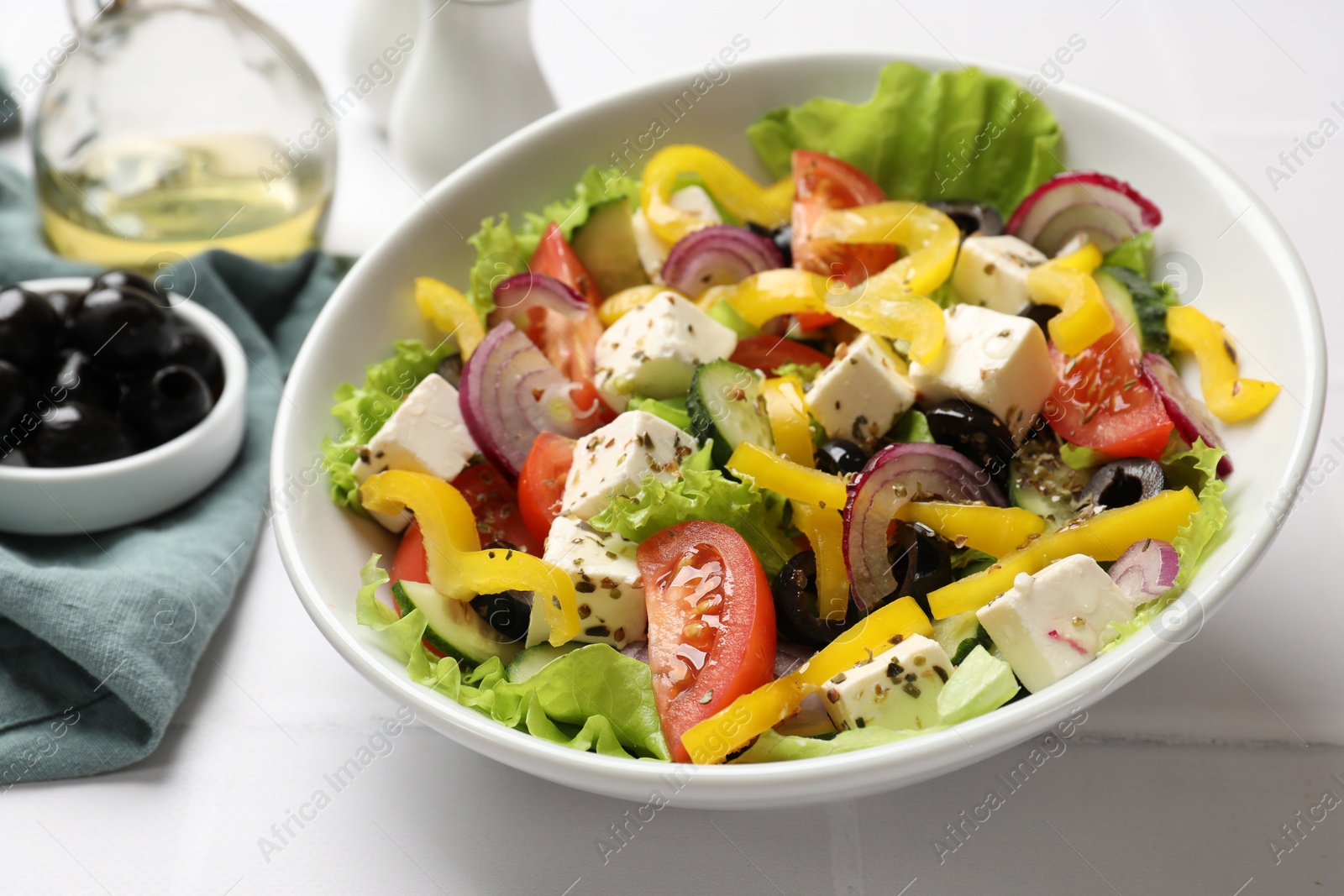 Photo of Delicious fresh Greek salad served on white table, closeup