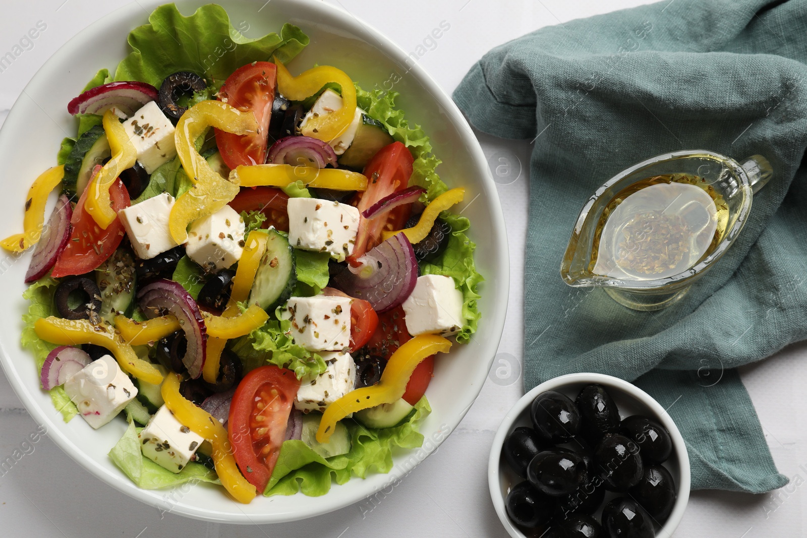 Photo of Delicious fresh Greek salad served on white table, flat lay