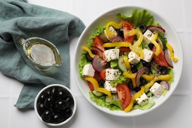 Photo of Delicious fresh Greek salad served on white table, flat lay