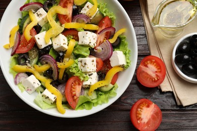 Photo of Delicious fresh Greek salad served on wooden table, flat lay