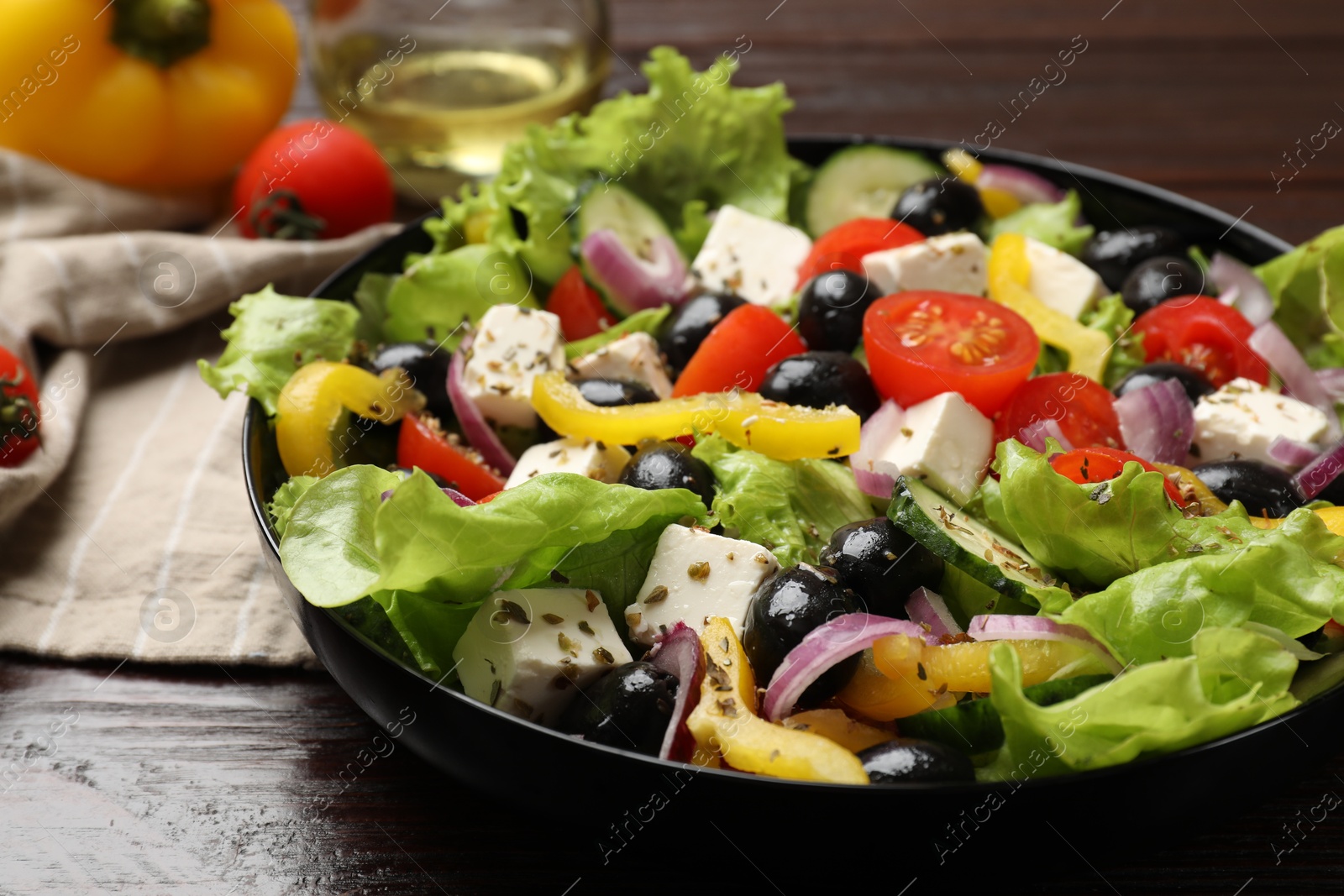 Photo of Delicious fresh Greek salad on wooden table, closeup