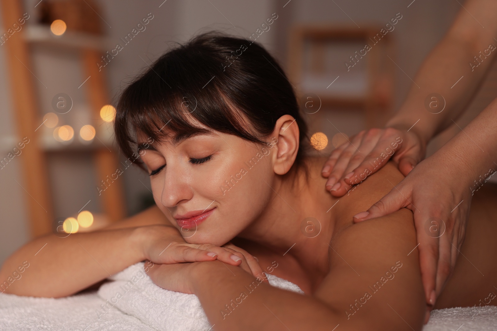 Photo of Young woman receiving massage in spa salon