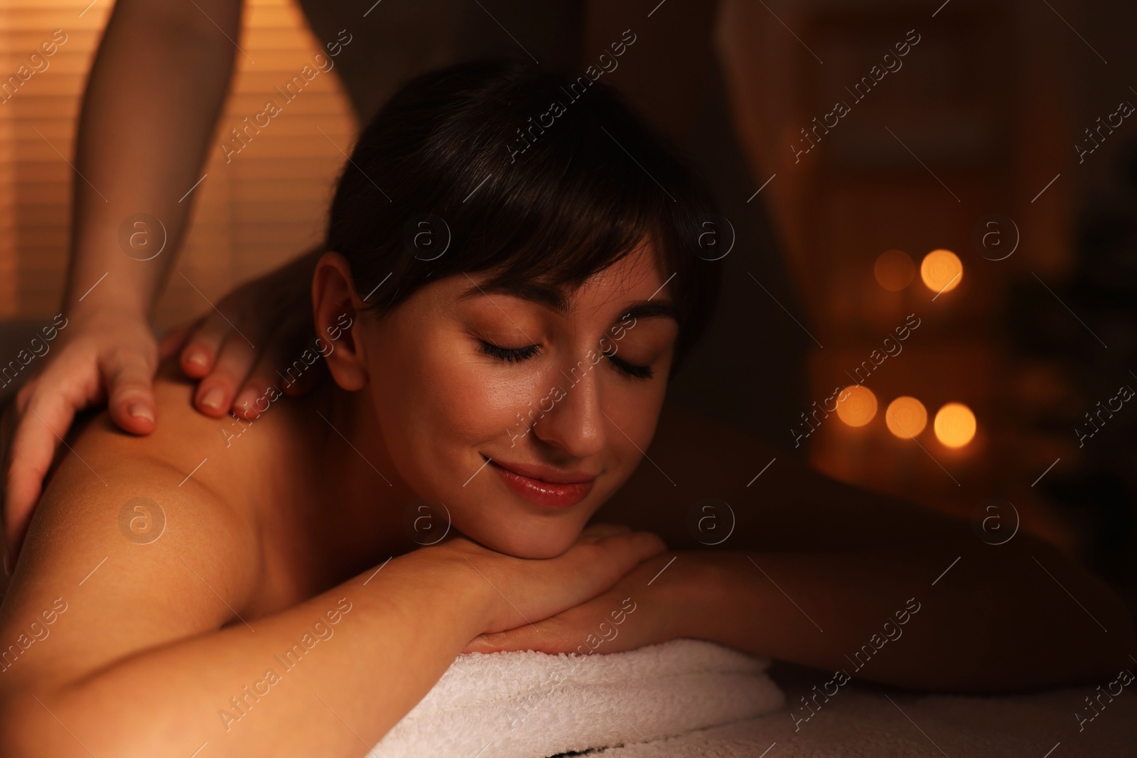 Photo of Young woman receiving massage in spa salon